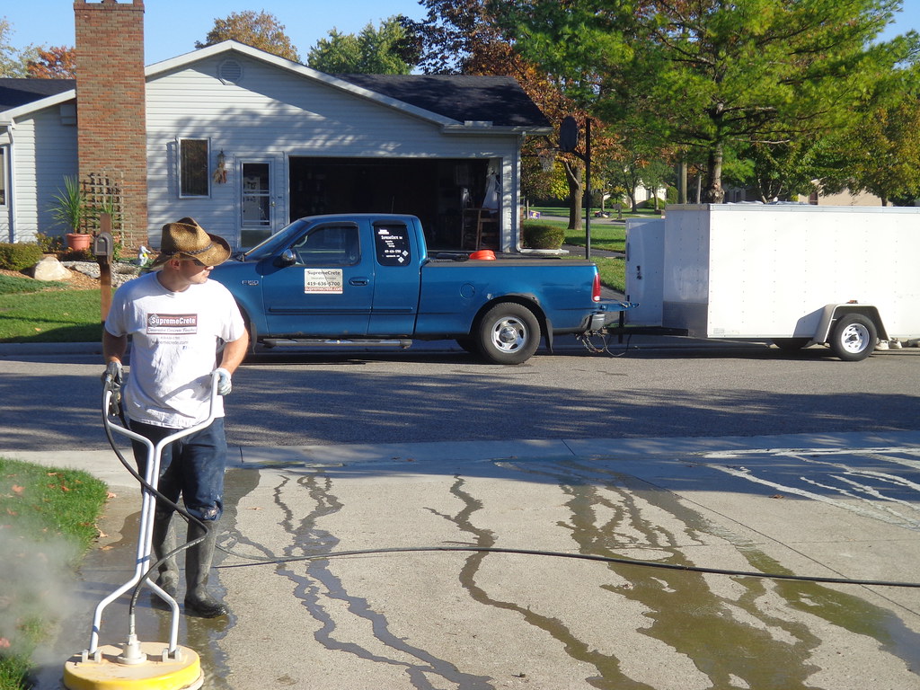Power washing a concrete driveway